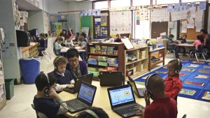 young students using laptops in classroom